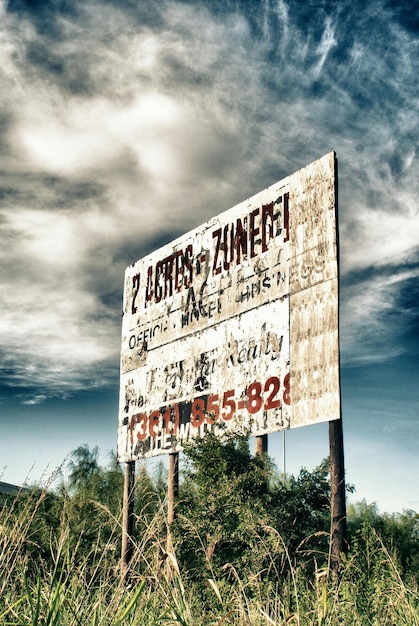 Foto vista de ángulo bajo del cartel contra el cielo nublado