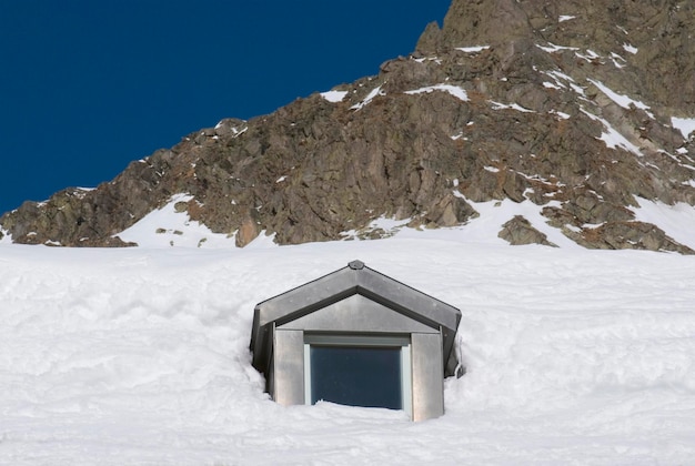 Vista de bajo ángulo de la casa en la montaña cubierta de nieve contra el cielo