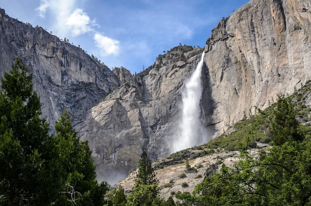 Vista de bajo ángulo de la cascada que cae de la montaña