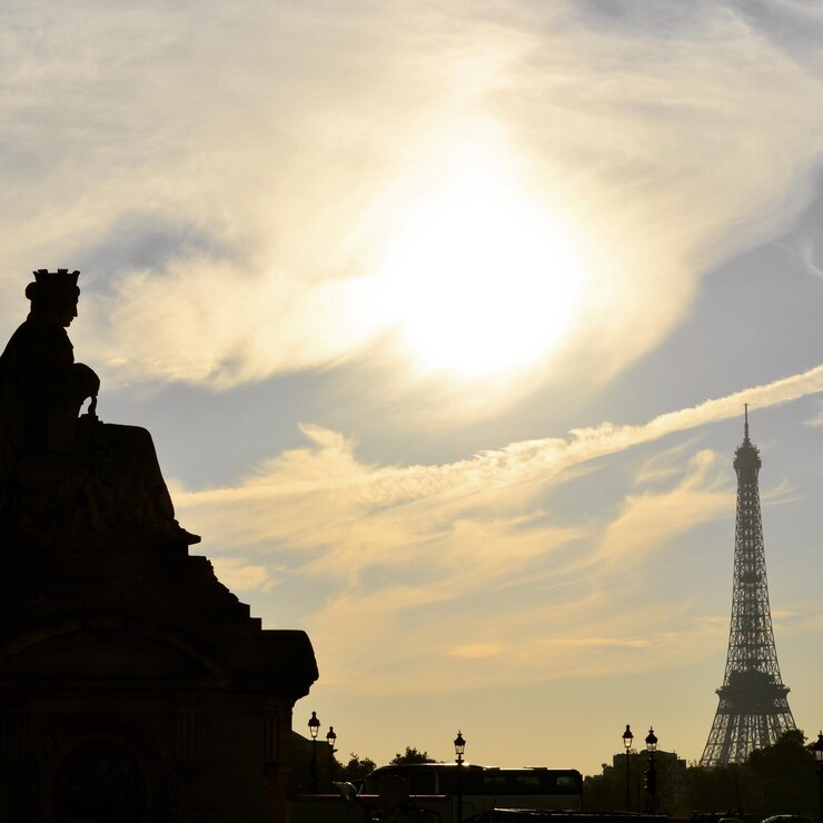 Foto vista de ángulo bajo del cielo nublado sobre el edificio y la torre eiffel