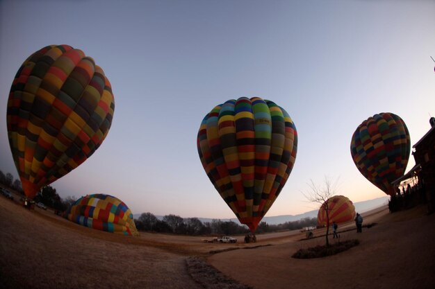 Foto vista de ángulo bajo de coloridos globos de aire caliente en el paisaje contra el cielo