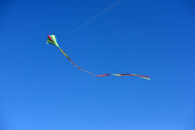 Vista de ángulo bajo de una cometa volando contra un cielo azul claro