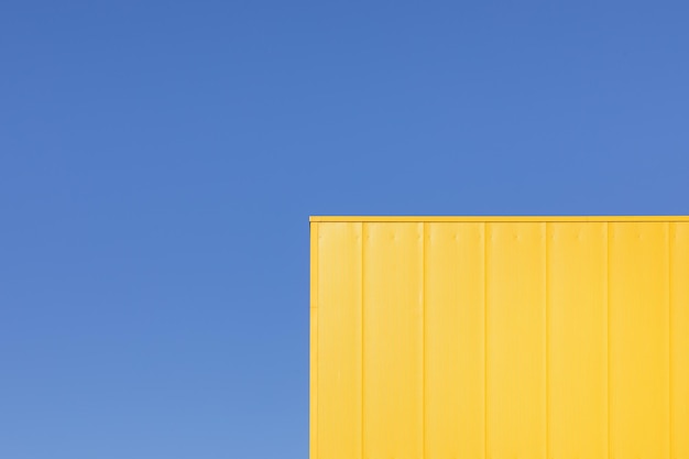 Foto vista de ángulo bajo de un contenedor de carga amarillo contra el cielo