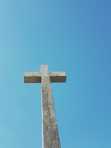 Foto vista de ángulo bajo de la cruz contra un cielo azul claro