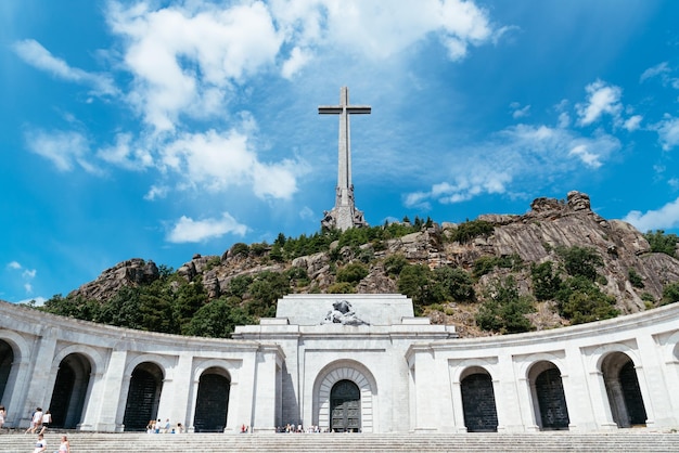 Vista en bajo ángulo del edificio histórico y la cruz contra el cielo azul