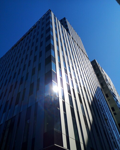 Foto vista de ángulo bajo de un edificio moderno contra un cielo azul claro