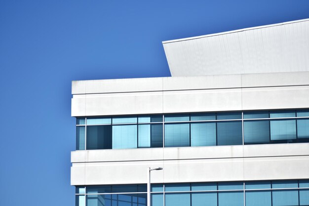 Vista de ángulo bajo de un edificio moderno contra un cielo azul claro