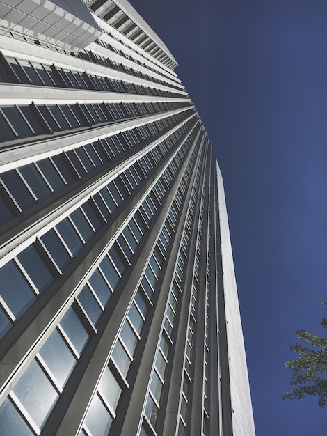 Vista de ángulo bajo de un edificio moderno contra un cielo azul claro