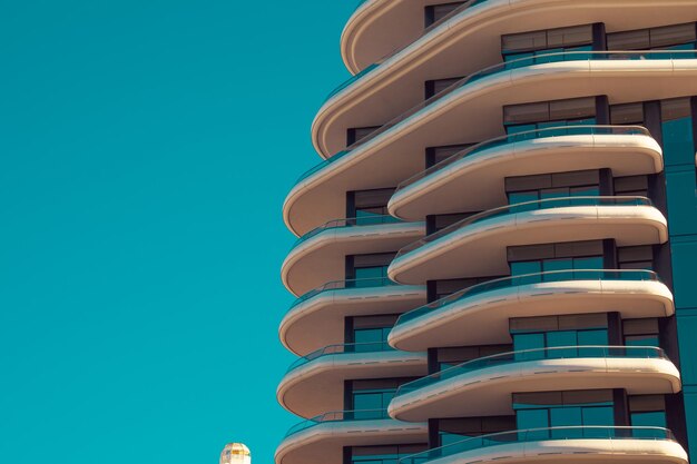 Foto vista de ángulo bajo de un edificio moderno contra un claro cielo azul turquesa