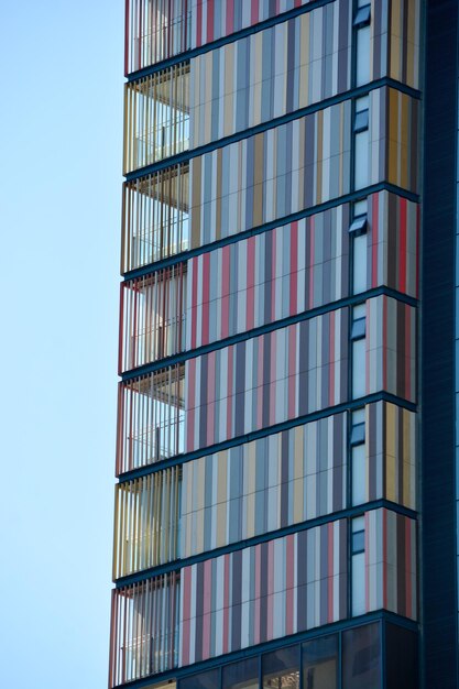 Foto vista de ángulo bajo de un edificio de vidrio contra un cielo azul claro