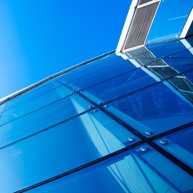 Foto vista de ángulo bajo de un edificio de vidrio contra el cielo azul