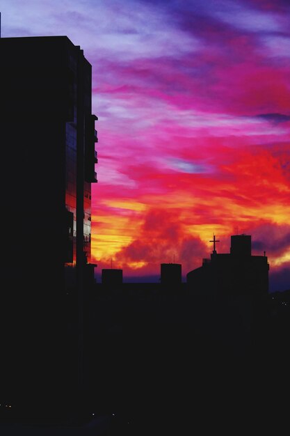 Foto vista de ángulo bajo de edificios de silueta contra el cielo durante la puesta de sol