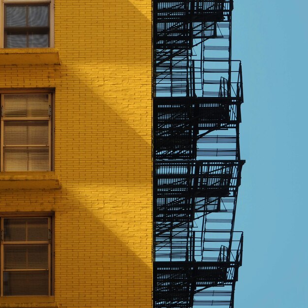 Foto vista de ángulo bajo de la escalera amarilla contra el edificio