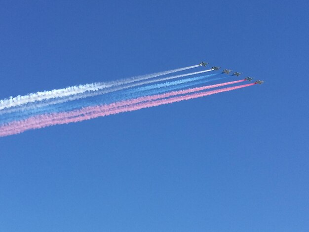 Foto vista de ángulo bajo del espectáculo aéreo contra un cielo azul claro