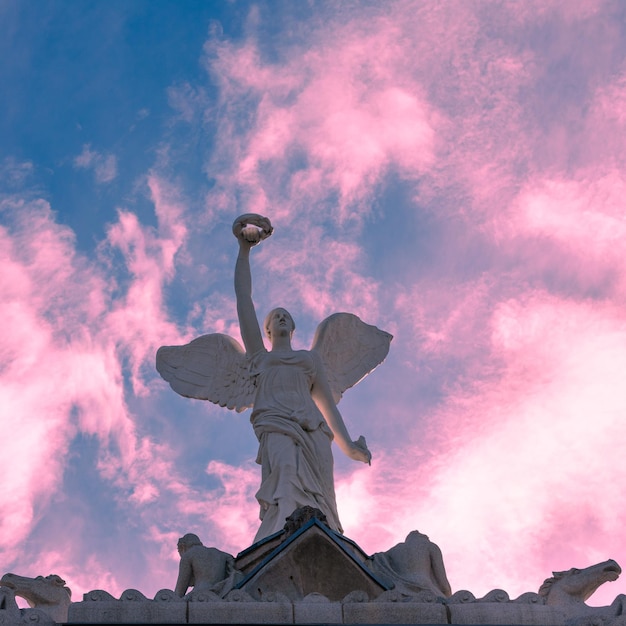 Foto vista en bajo ángulo de la estatua de un ángel contra el cielo durante la puesta de sol