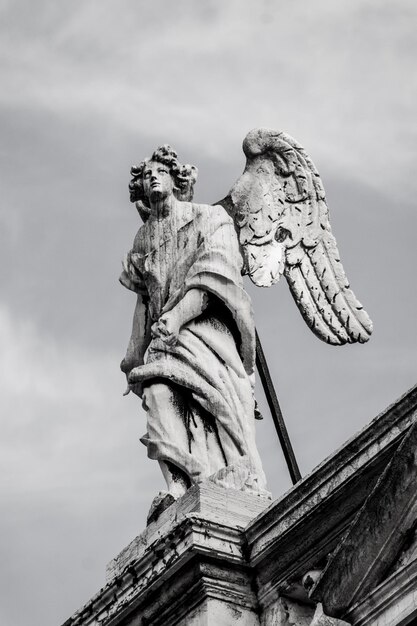 Foto vista en bajo ángulo de la estatua de un ángel contra el cielo