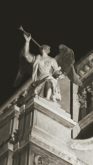 Foto vista de bajo ángulo de la estatua contra el cielo por la noche