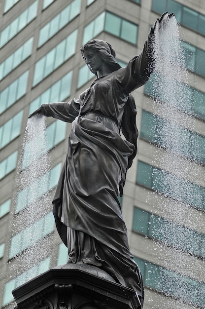 Vista de bajo ángulo de la estatua contra los edificios de la ciudad