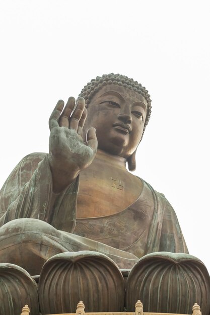 Foto vista de bajo ángulo de la estatua contra el templo contra el cielo despejado