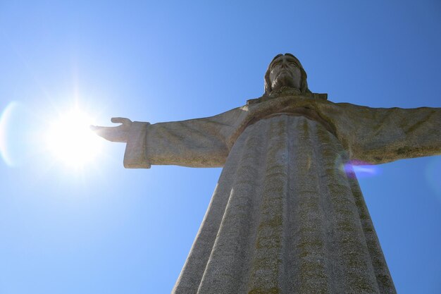 Foto vista de bajo ángulo de la estatua de jesús contra el cielo azul claro