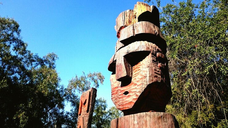 Foto vista de ángulo bajo de la estatua de madera por los árboles contra el cielo