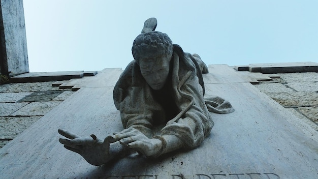 Vista de ángulo bajo de la estatua en la pared contra el cielo en la ciudad