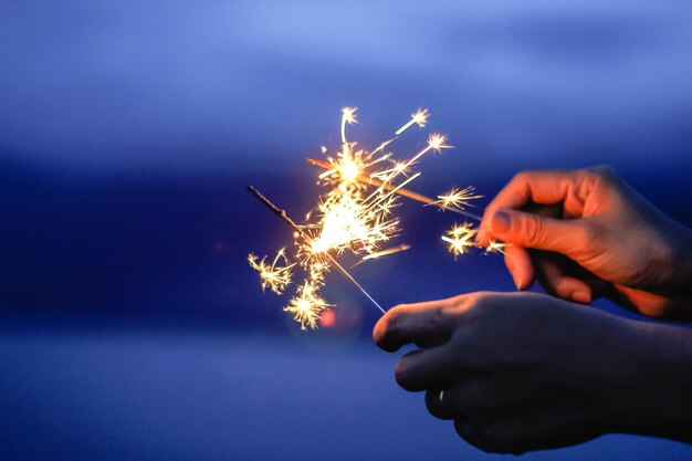 Vista de ángulo bajo de la exhibición de fuegos artificiales en la mano por la noche