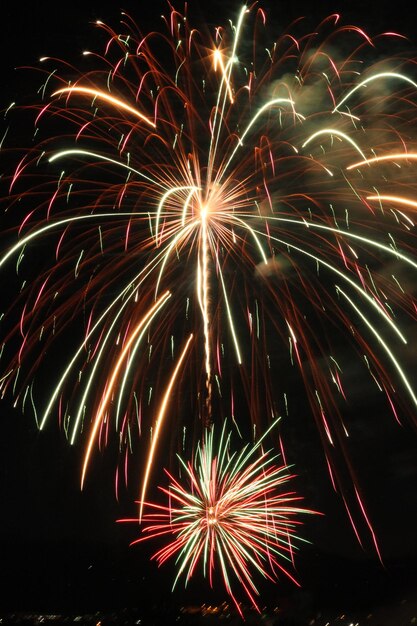 Foto vista de bajo ángulo de la exhibición de fuegos artificiales por la noche