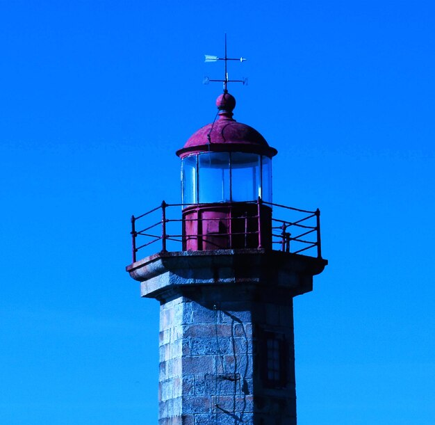 Foto vista de bajo ángulo del faro contra un cielo azul claro