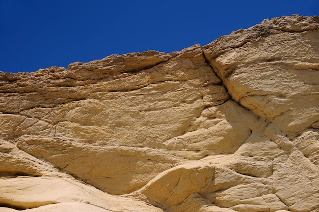 Foto vista de ángulo bajo de formaciones rocosas contra un cielo azul claro