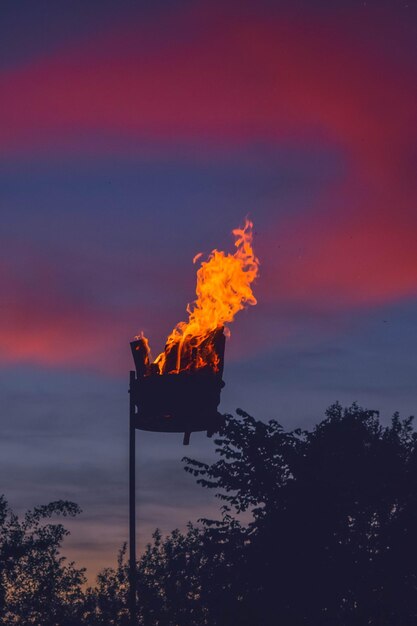Vista de ángulo bajo de fuego naranja contra el cielo al atardecer