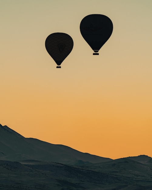 Foto vista de ángulo bajo de globos de aire caliente contra el cielo durante la puesta del sol