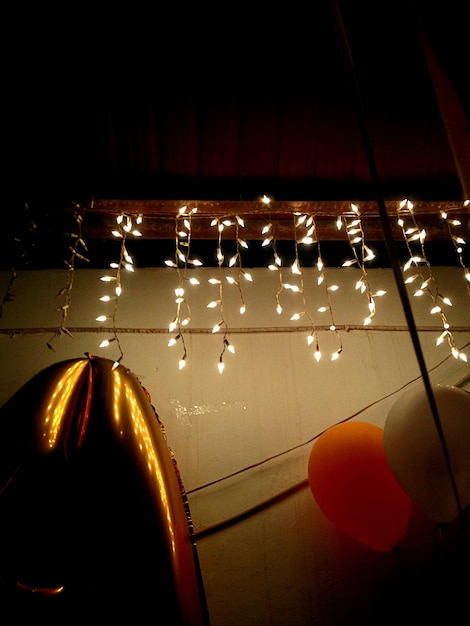 Vista de ángulo bajo de globos y decoraciones iluminadas contra la pared