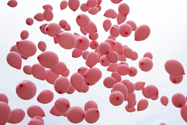 Vista de bajo ángulo de globos rosados volando contra un cielo despejado