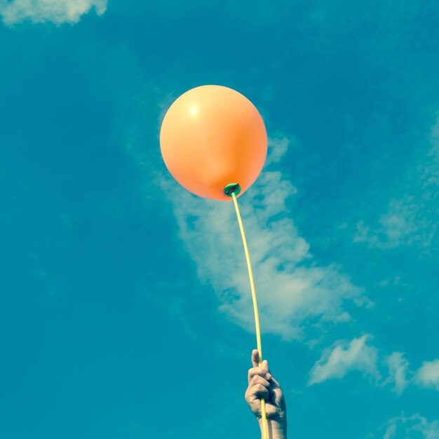 Vista de bajo ángulo de globos volando contra el cielo azul