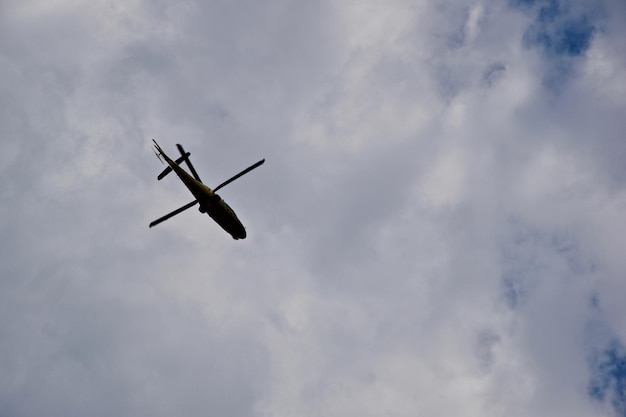 Vista de bajo ángulo de un helicóptero volando en un cielo nublado