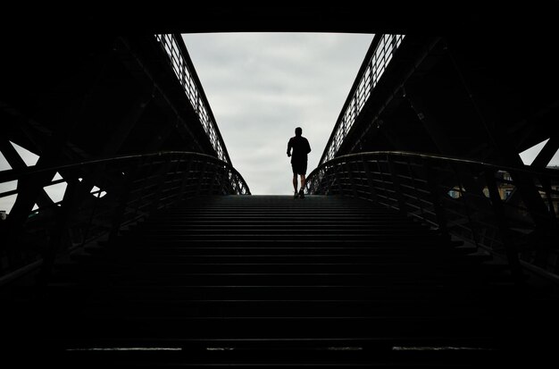 Vista de bajo ángulo del hombre en la escalera contra el cielo