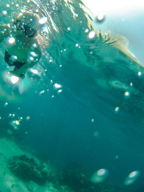 Foto vista de bajo ángulo de un hombre nadando en el mar