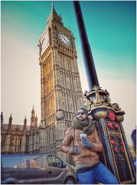 Foto vista de ángulo bajo de un hombre de pie contra el big ben