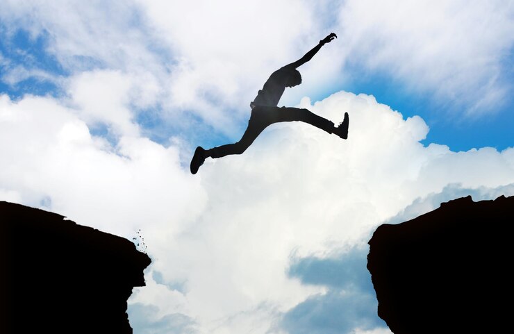 Foto vista de bajo ángulo de un hombre saltando contra el cielo nublado