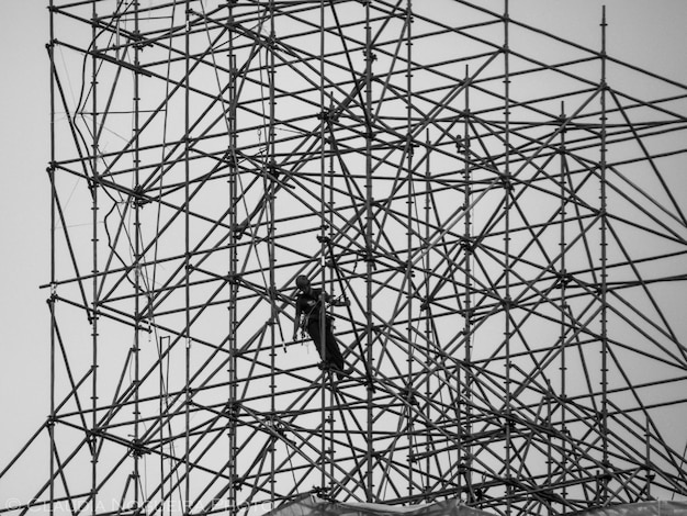 Vista de bajo ángulo del hombre en el sitio de construcción contra el cielo