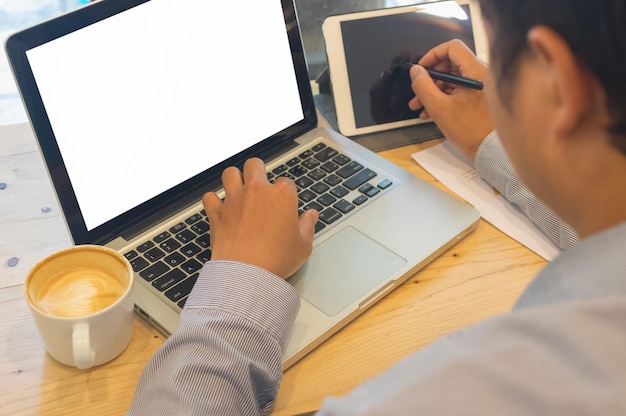 Vista de bajo ángulo de un hombre usando una computadora portátil en la mesa