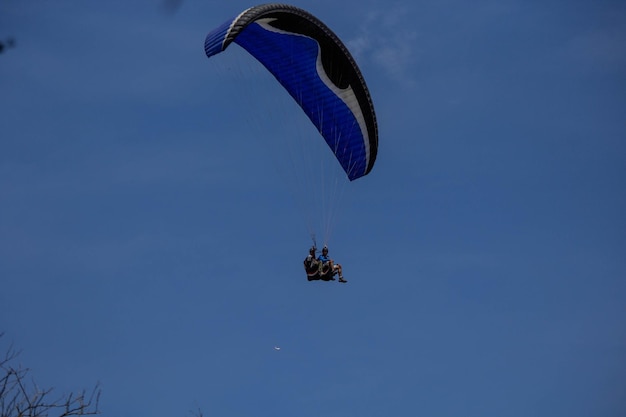 Vista de bajo ángulo de hombres en parapente en el cielo azul