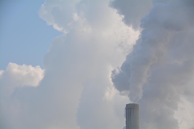 Foto vista en bajo ángulo del humo que emite la chimenea contra el cielo