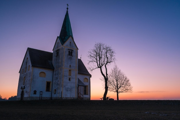 Vista de bajo ángulo de la iglesia en el campo al atardecer