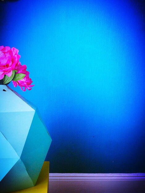 Vista de ángulo bajo de un jarrón de flores contra el techo azul