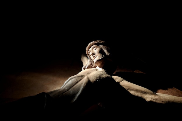 Foto vista de bajo ángulo de jesucristo en cuarto oscuro