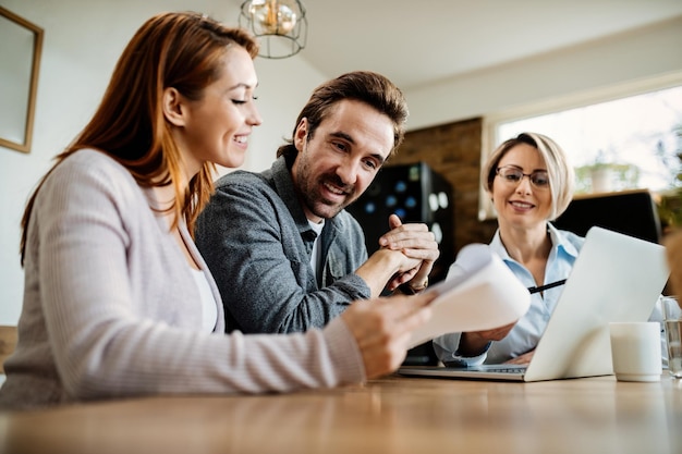 Vista de ángulo bajo de una joven pareja feliz que tiene consultas con su asesor financiero en casa El foco está en el hombre