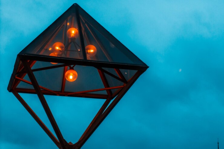 Foto vista de ángulo bajo de la lámpara iluminada contra el cielo azul