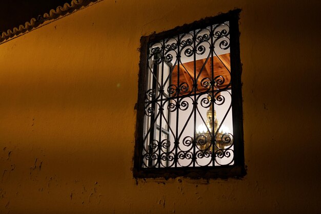 Vista de ángulo bajo de la lámpara iluminada vista desde la ventana